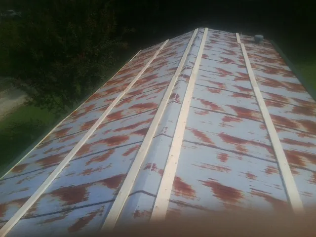 Rusted metal roof panels with new wood purlins before replacement — Storm Damage Roof Repair in Baxley by Roofing Brothers