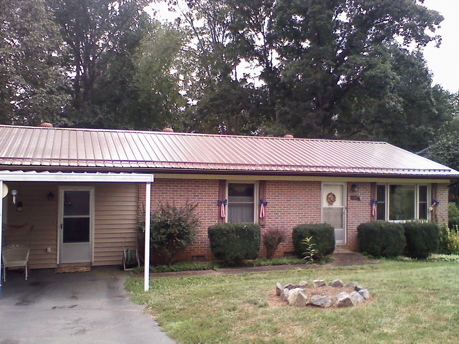 Bronze metal roof and carport on a brick ranch home — Roof Repair work by our crew in Baxley
